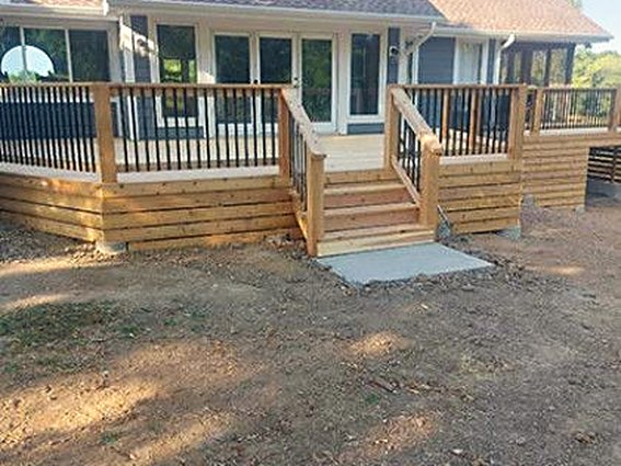 The same home with a newly built deck, railing and stairs in place.