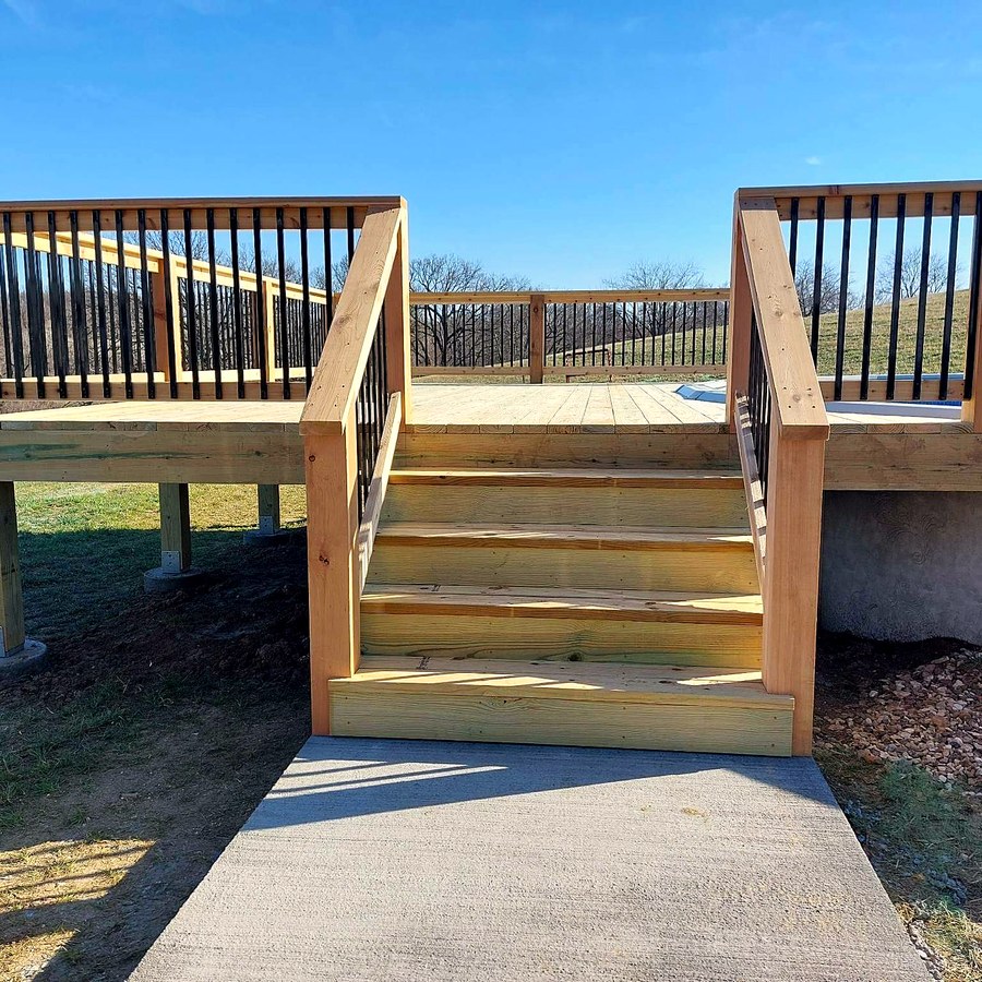 Cedar deck with black aluminum balusters and a wide stair run.