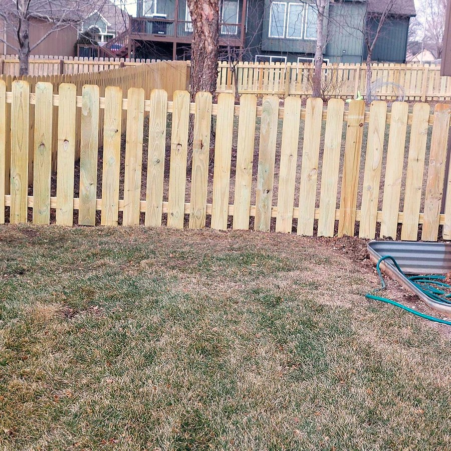 New cedar picket fence along a property line.
